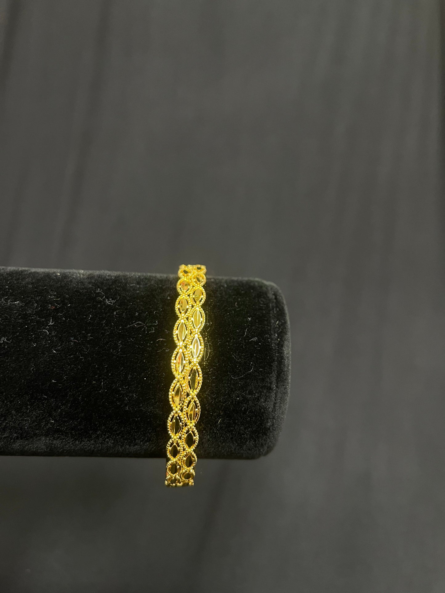 Elegant Gold Imitated design bracelet with intricate linked pattern on black display stand