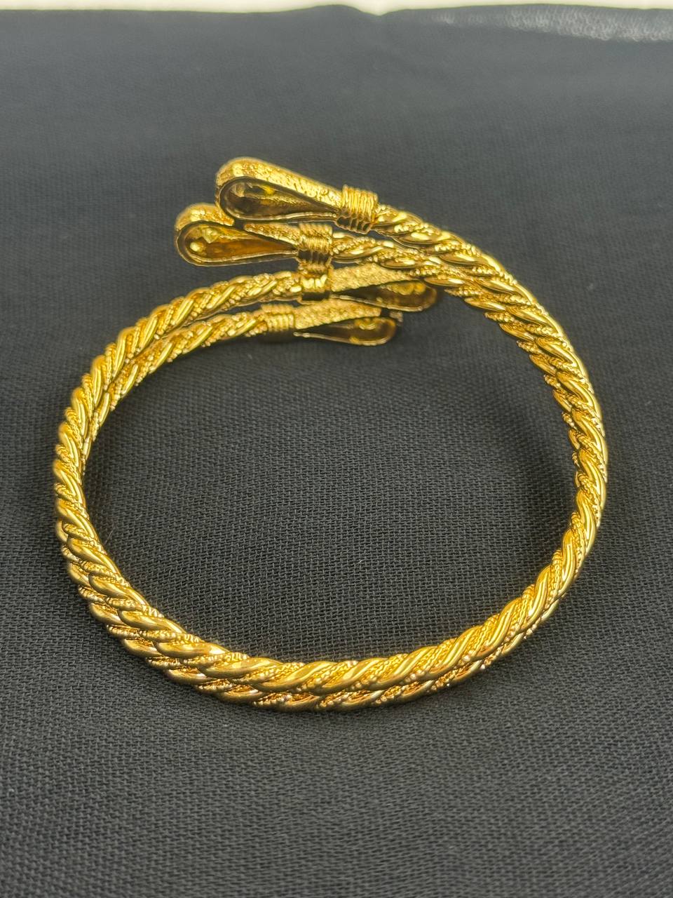 Palestinian Elegance imitated gold mabroume bracelet gold twist with detailed rope design on black background