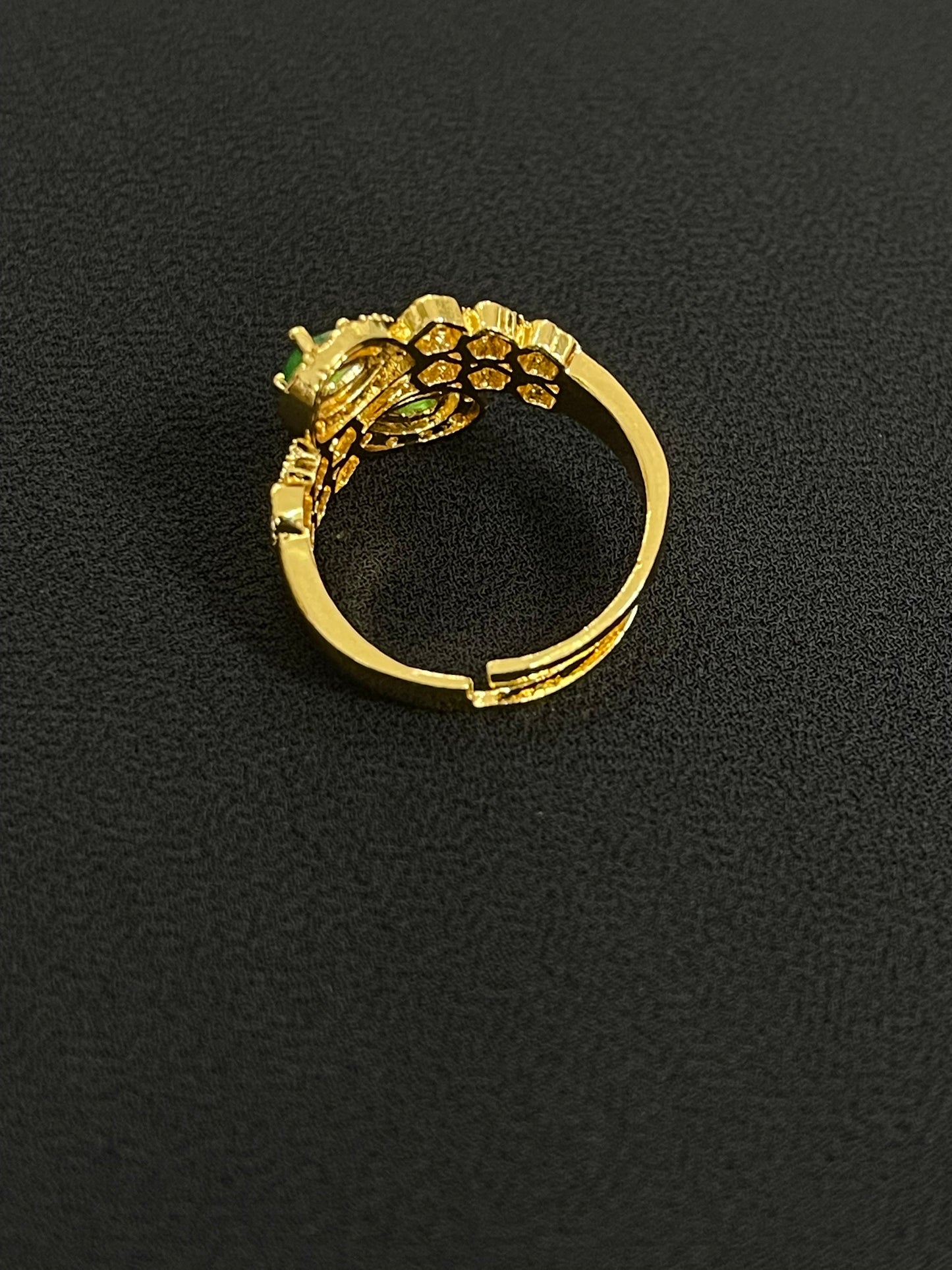 Gold adjustable ring from Palestinian gold jewelry set with intricate floral design and green stone accents
