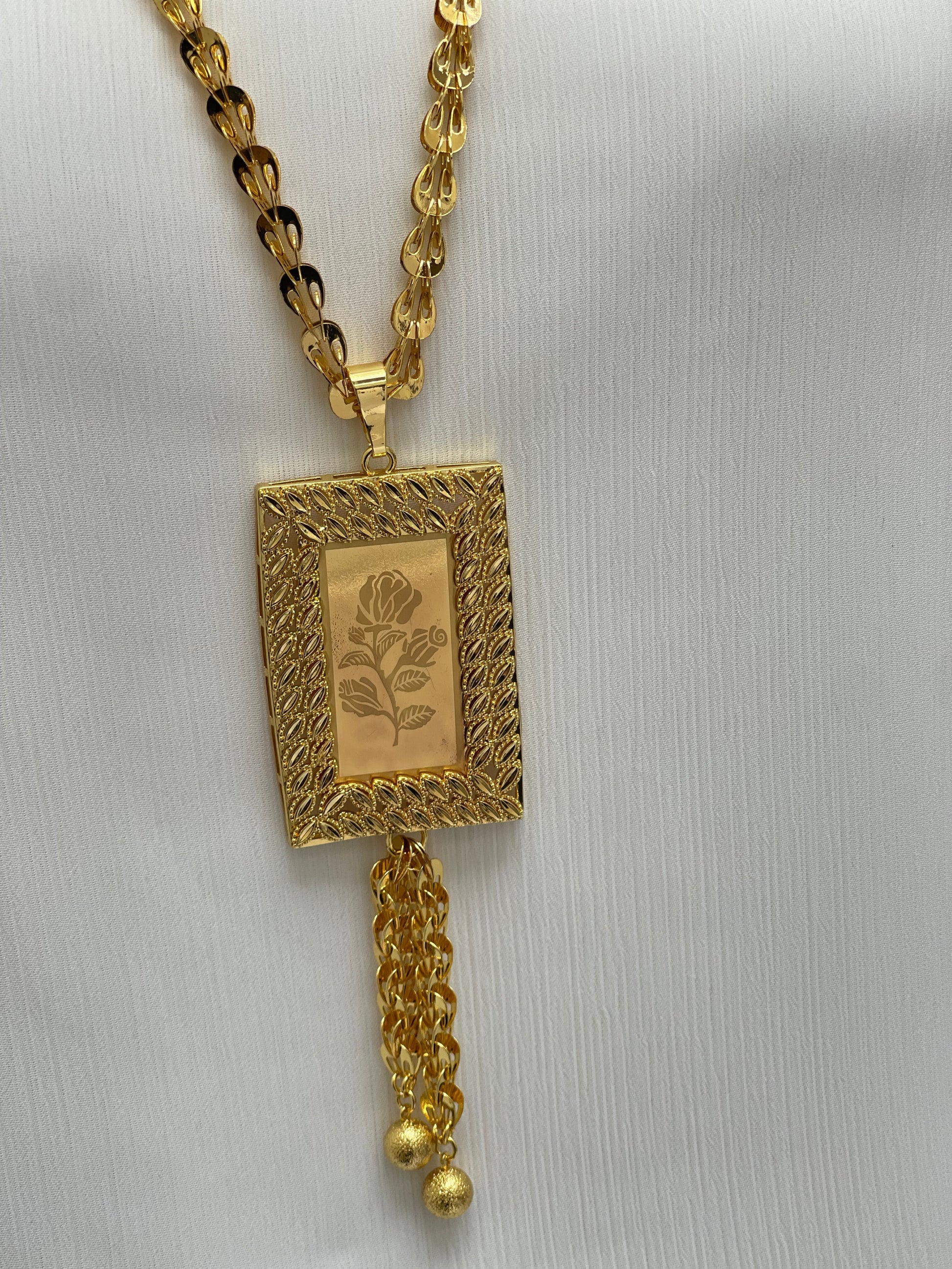 Palestinian Elegance long rose pendant necklace in gold with intricate rectangular design and chain tassel detail