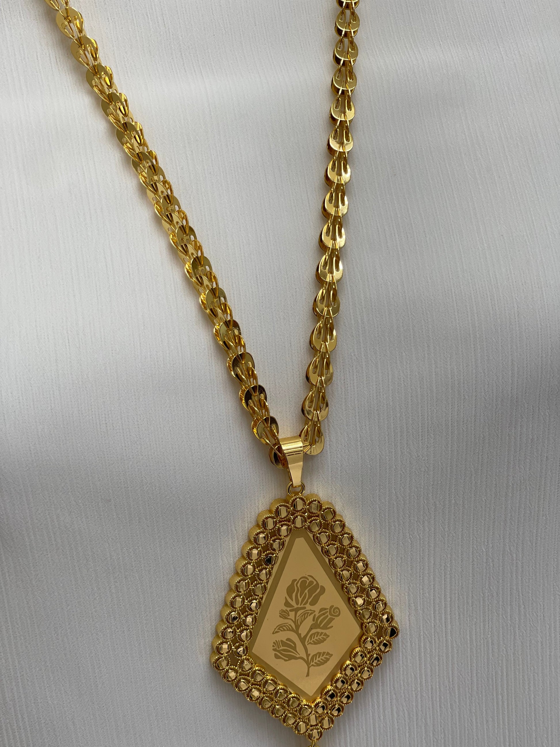 Palestinian Elegance long rose pendant necklace in gold with intricate floral design on pendant