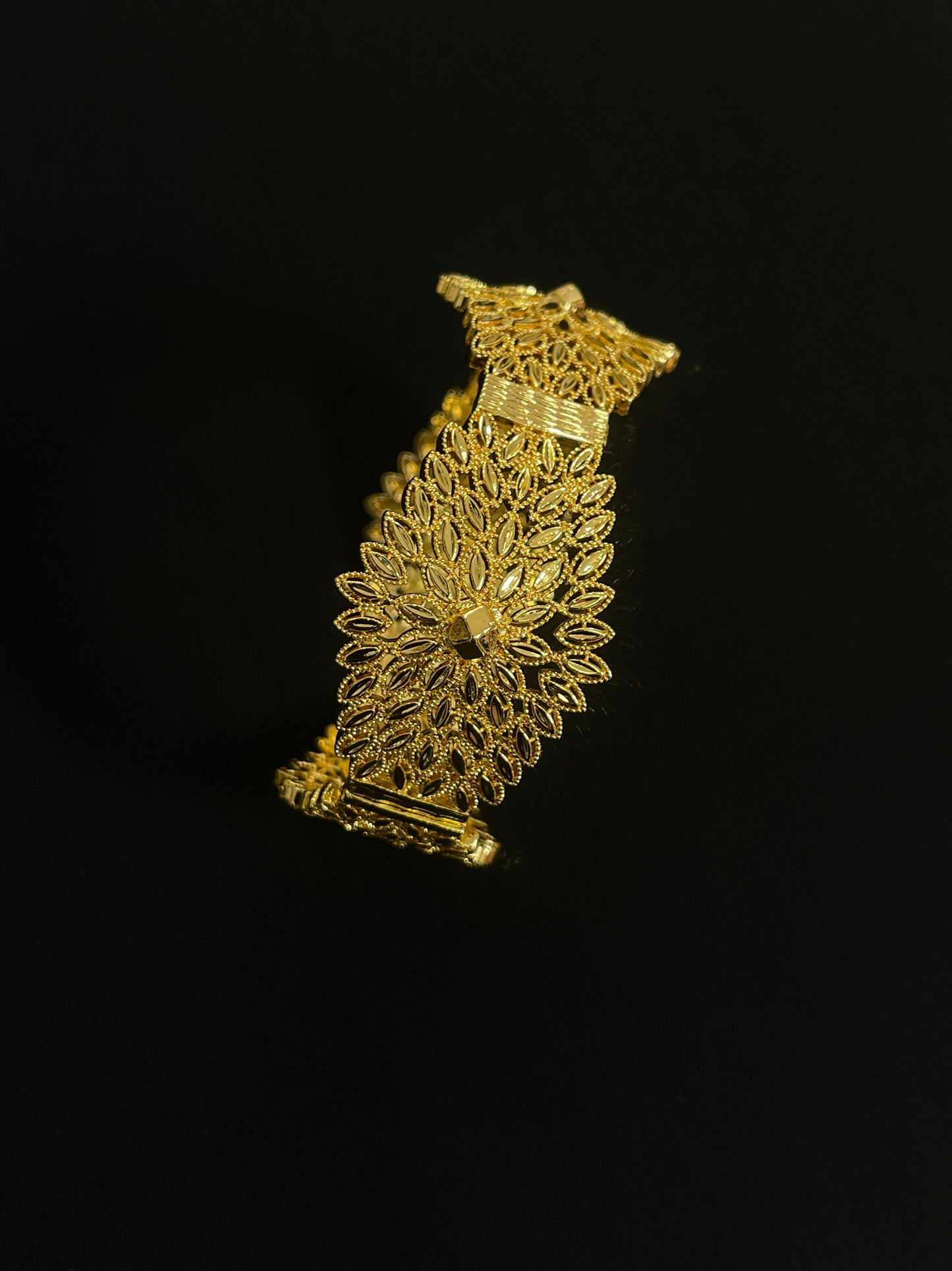 Intricate Palestinian gold jewelry set bracelet with delicate floral filigree design on black background