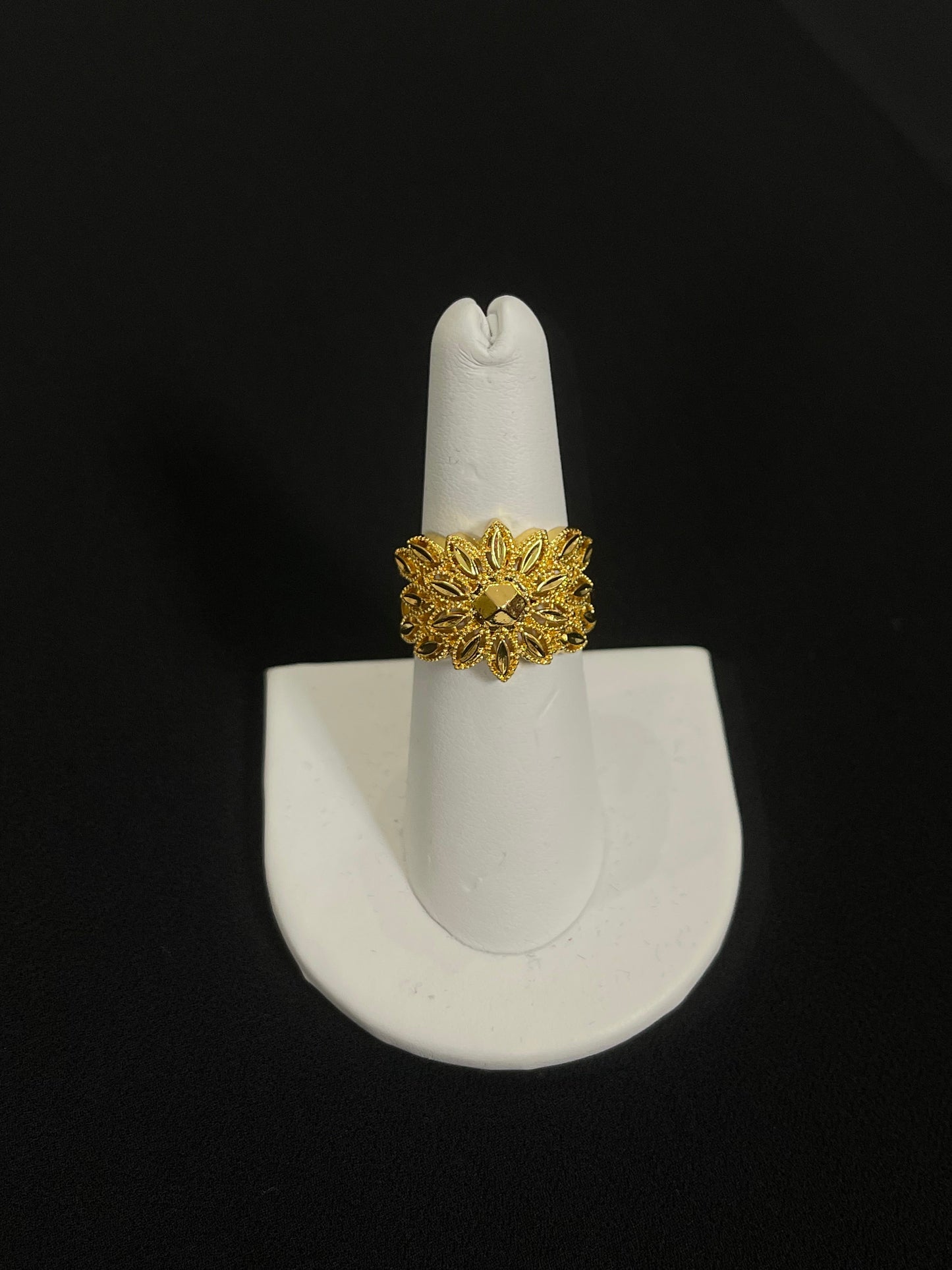 Intricate Palestinian gold jewelry set ring with floral design displayed on white stand