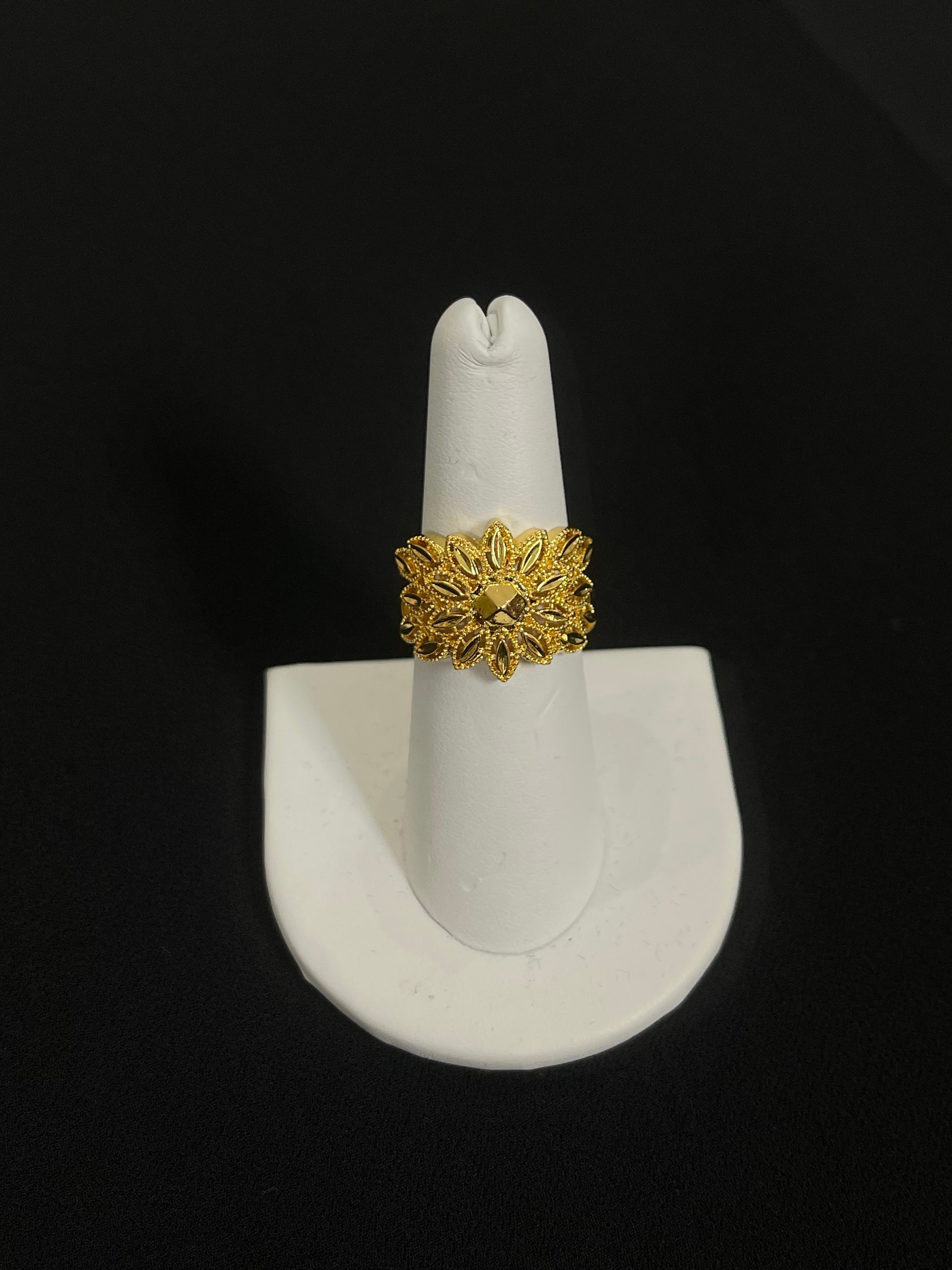 Intricate Palestinian gold jewelry set ring with floral design displayed on white stand