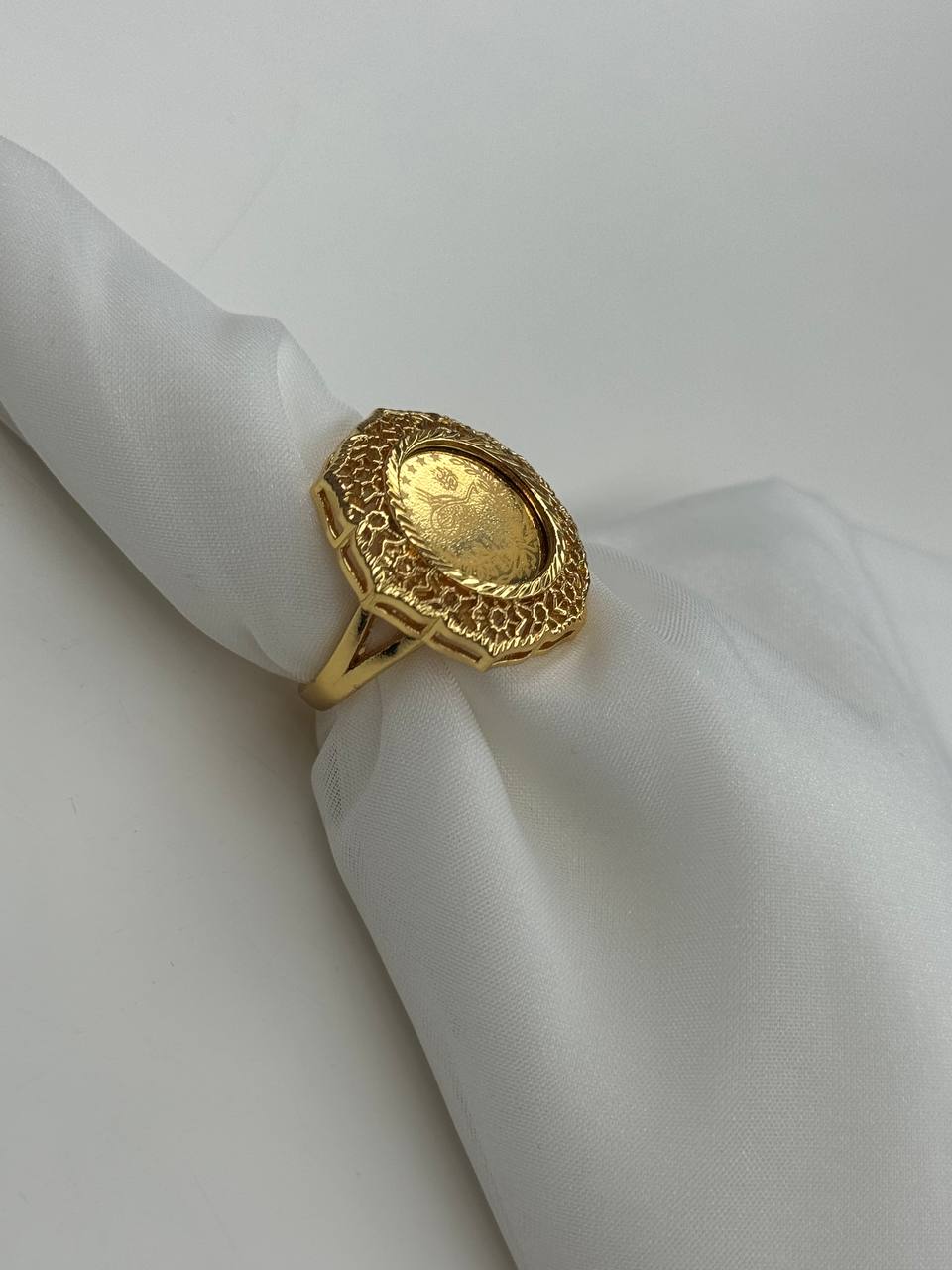 Palestinian Elegance falahi ring gold plated with intricate textured design on white fabric