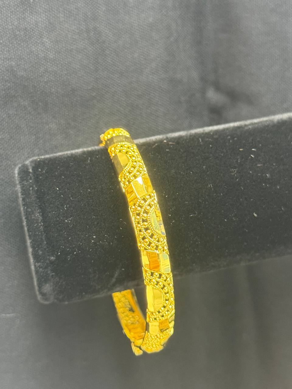 Palestinian Elegance imitated gold bangle bracelet for women with intricate design on black stand
