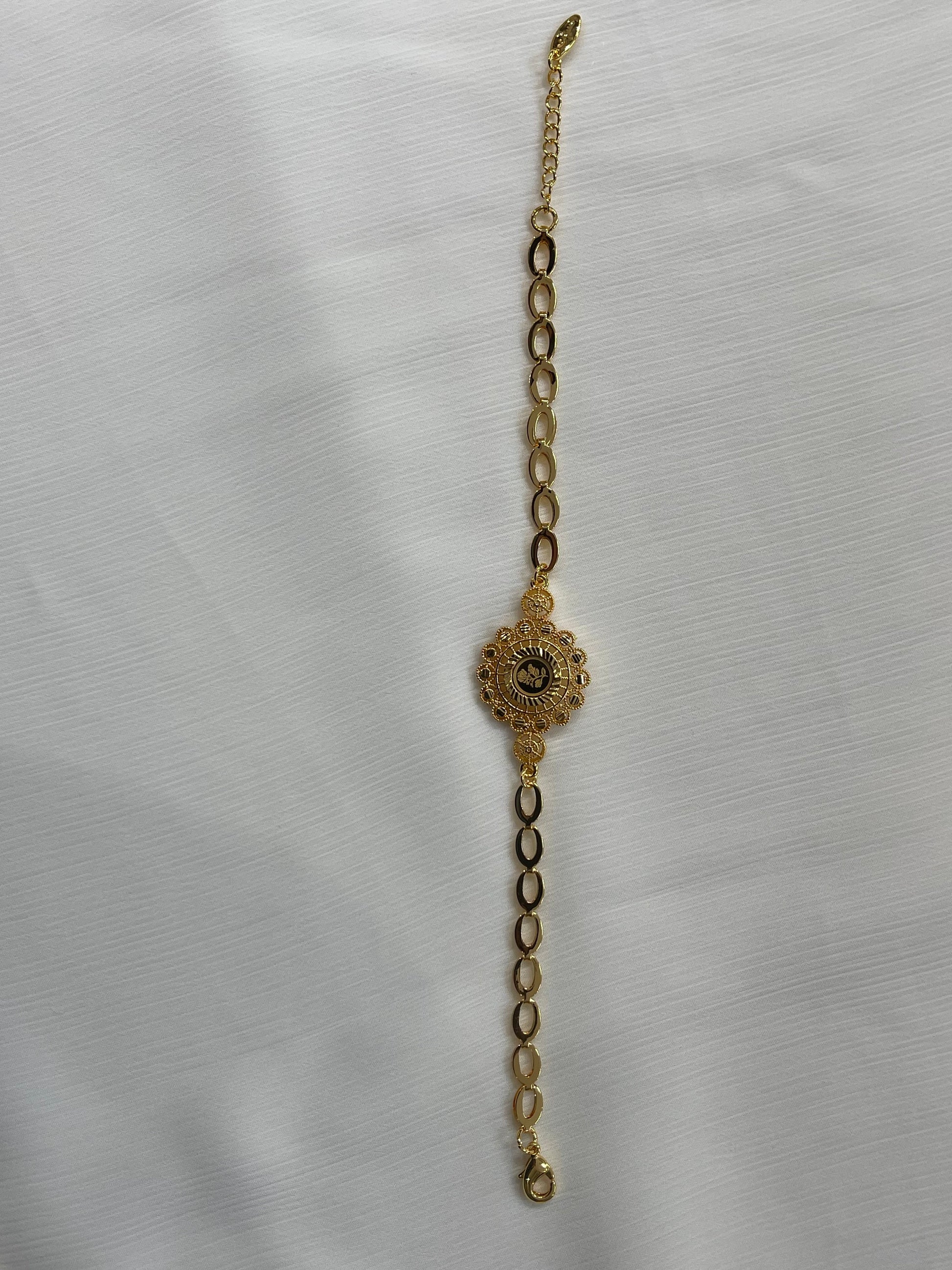 Delicate gold jewelry set for women featuring an elegant linked bracelet with a floral centerpiece