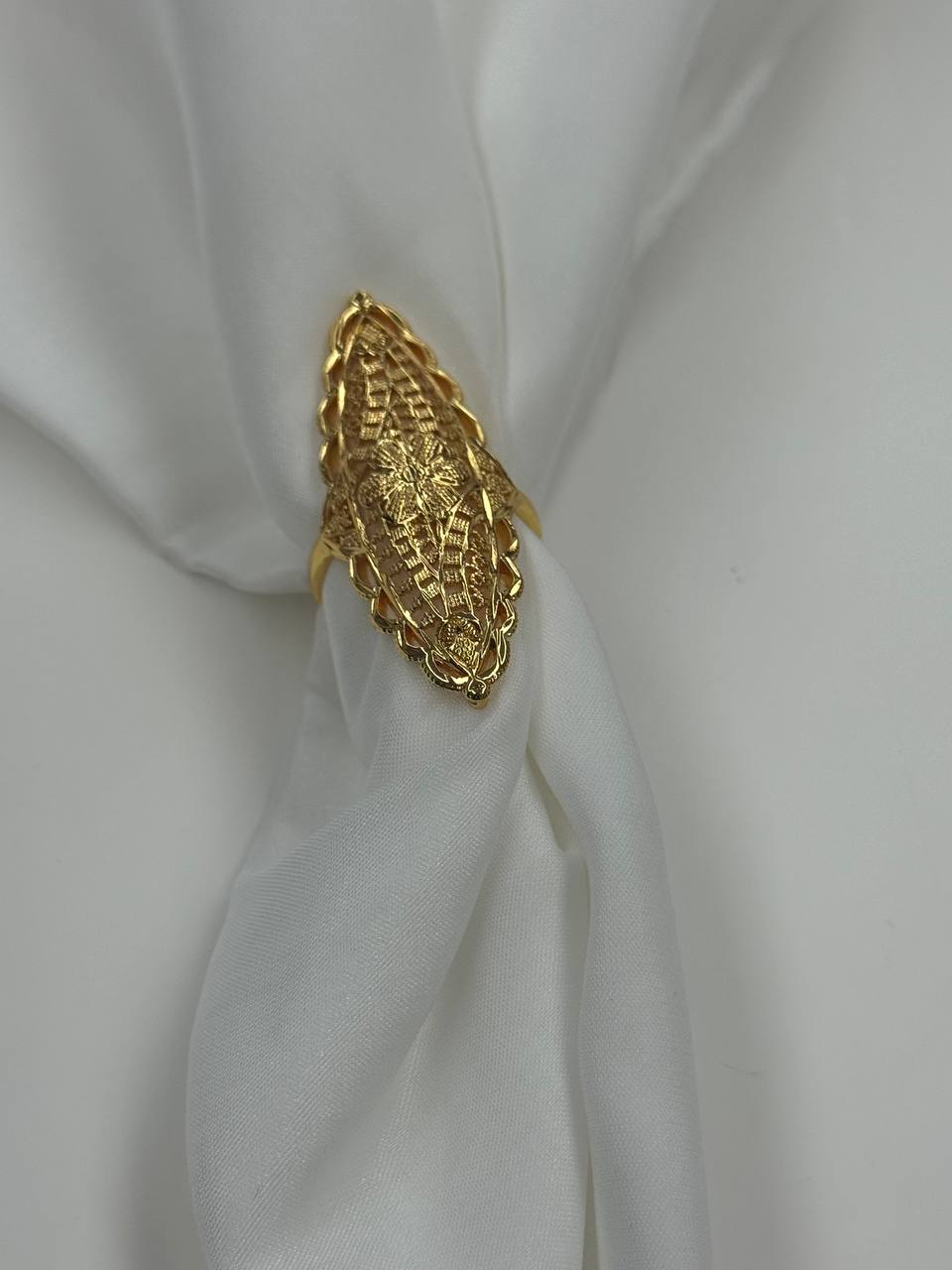 Imitated gold unique flower ring design by Palestinian Elegance on white fabric