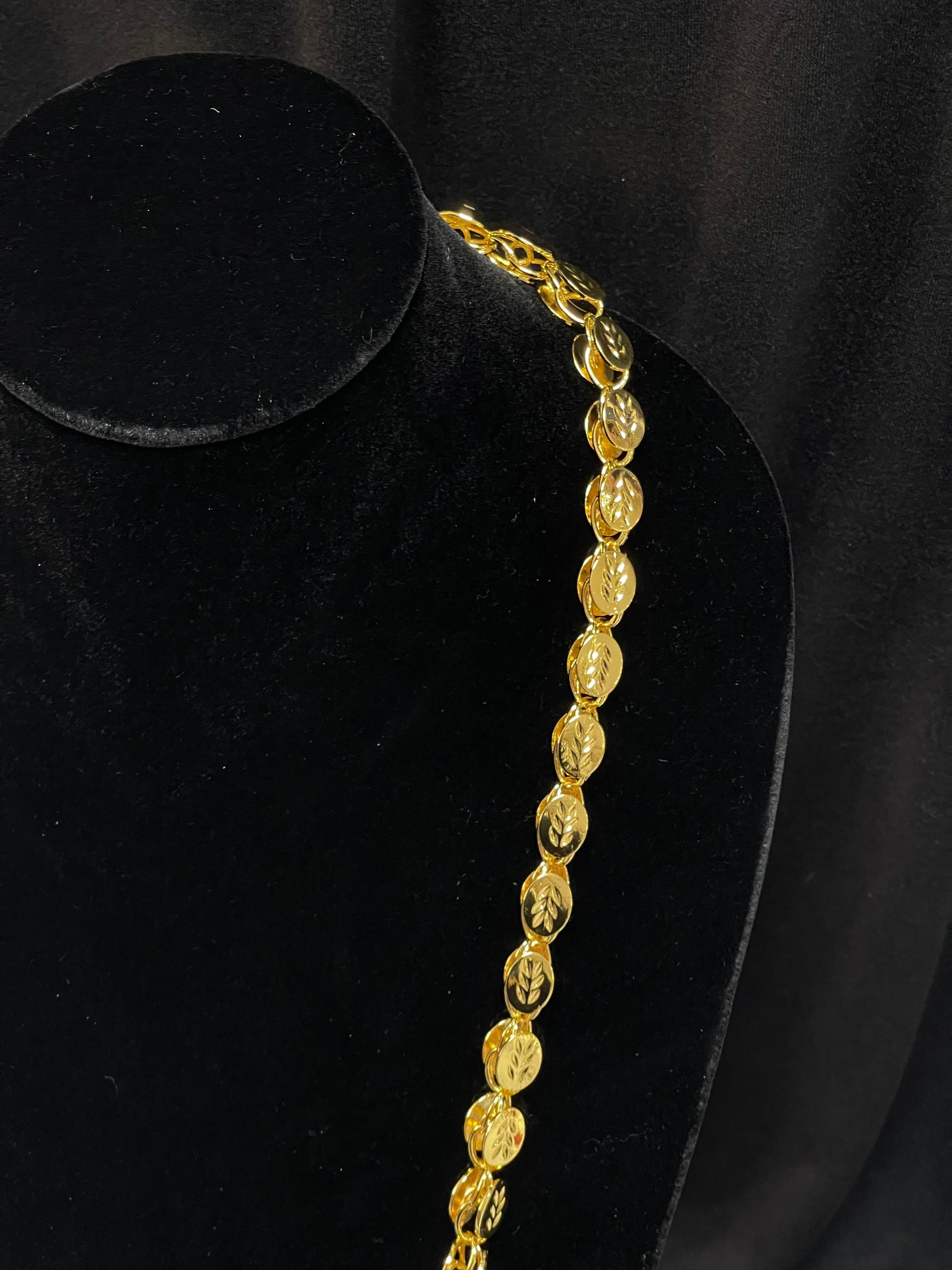 Halabi imitation gold necklace with intricate oval links displayed on a black velvet bust