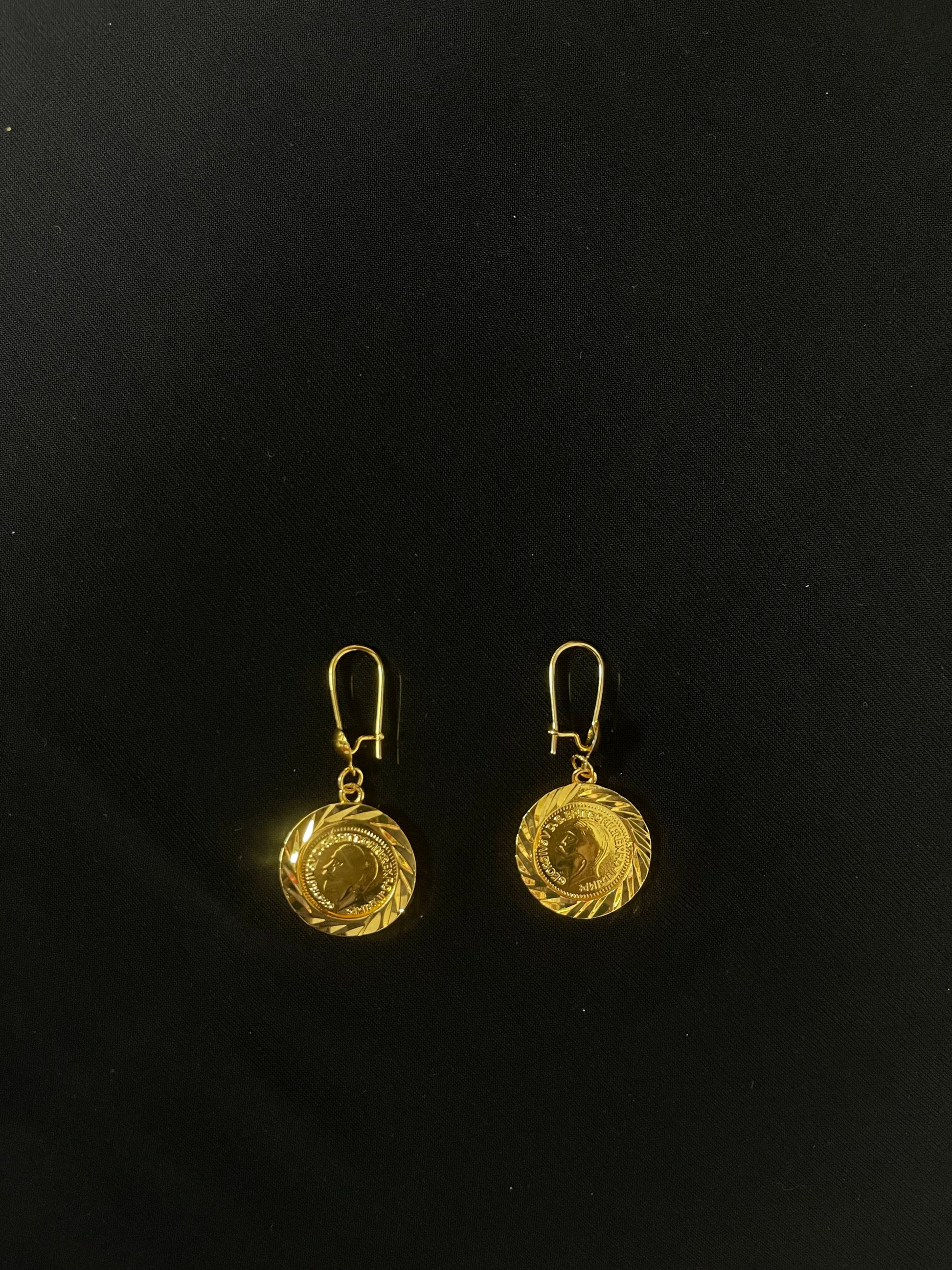 Palestinian Elegance imitated gold earrings with round coin pendant design on black background