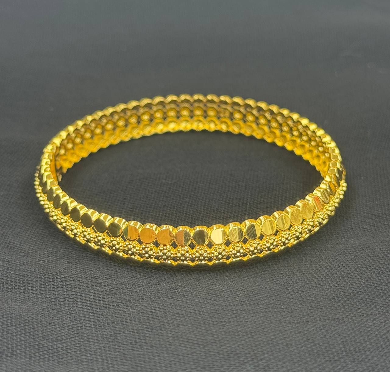 Palestinian Elegance imitation gold bangle bracelet with intricate textured design in bright gold tone