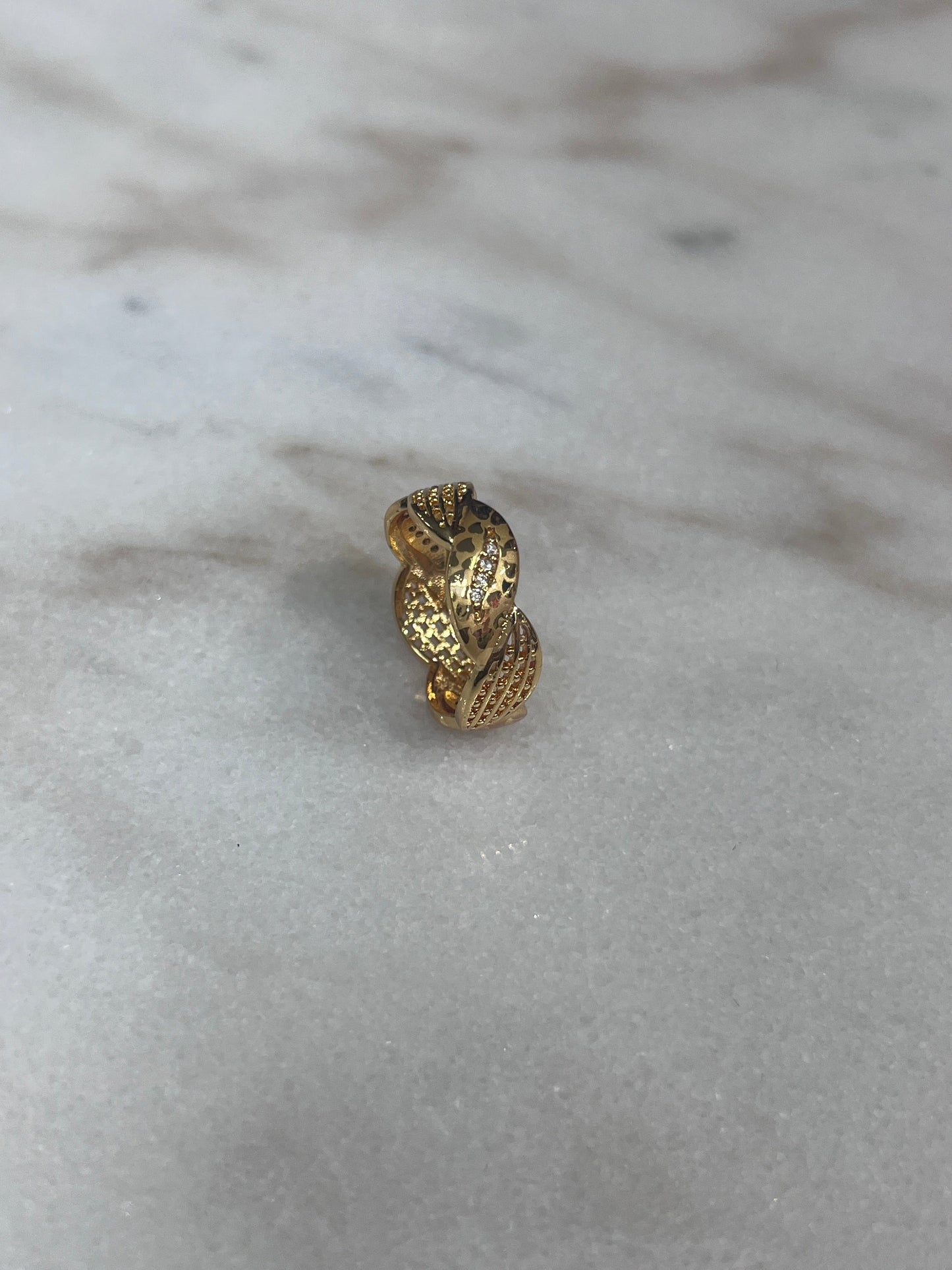 Palestinian Elegance imitation gold heart ring with intricate textured design on marble surface