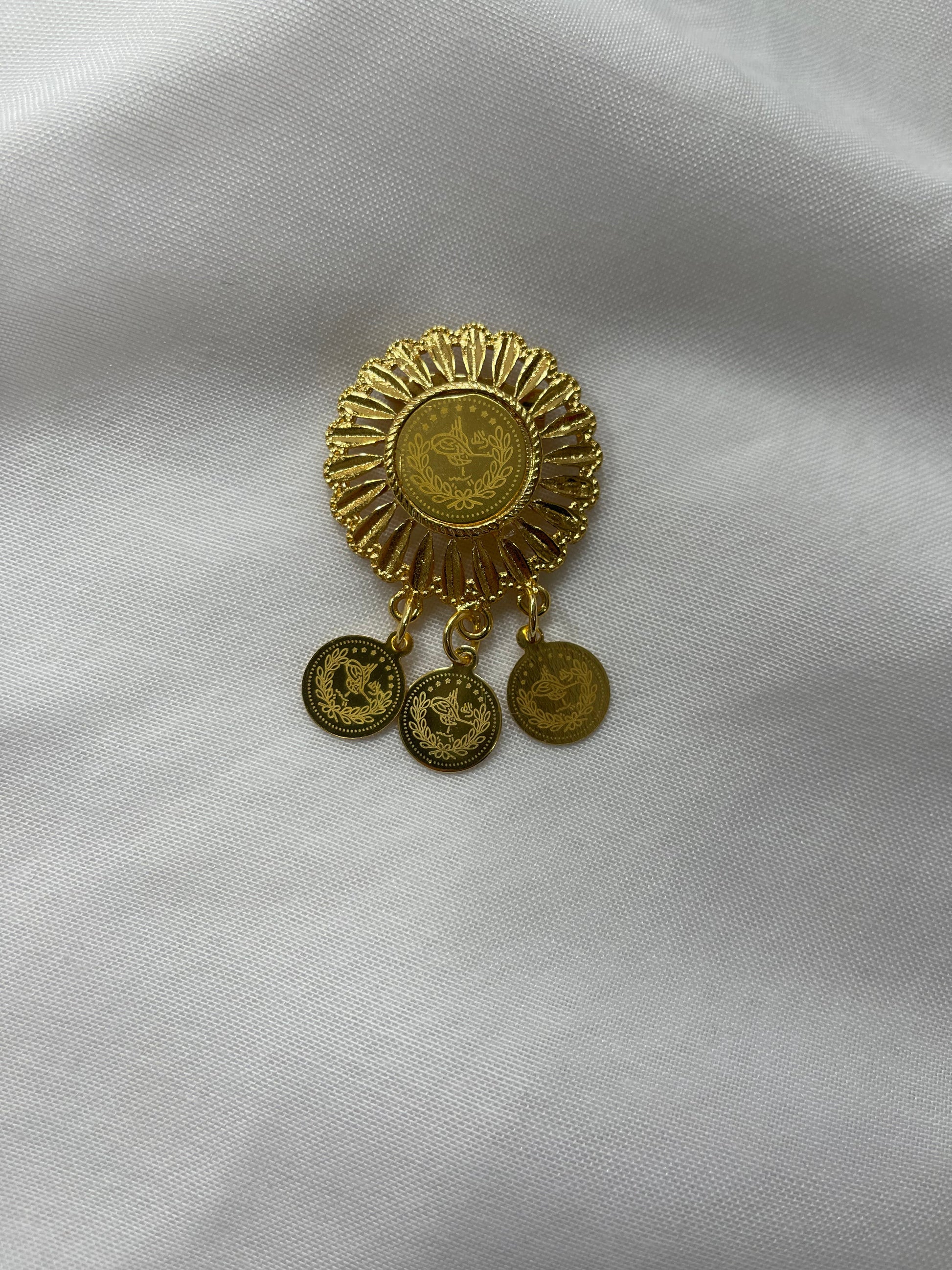 Palestinian Elegance imitation gold lapel pin with intricate circular design and three dangling coins