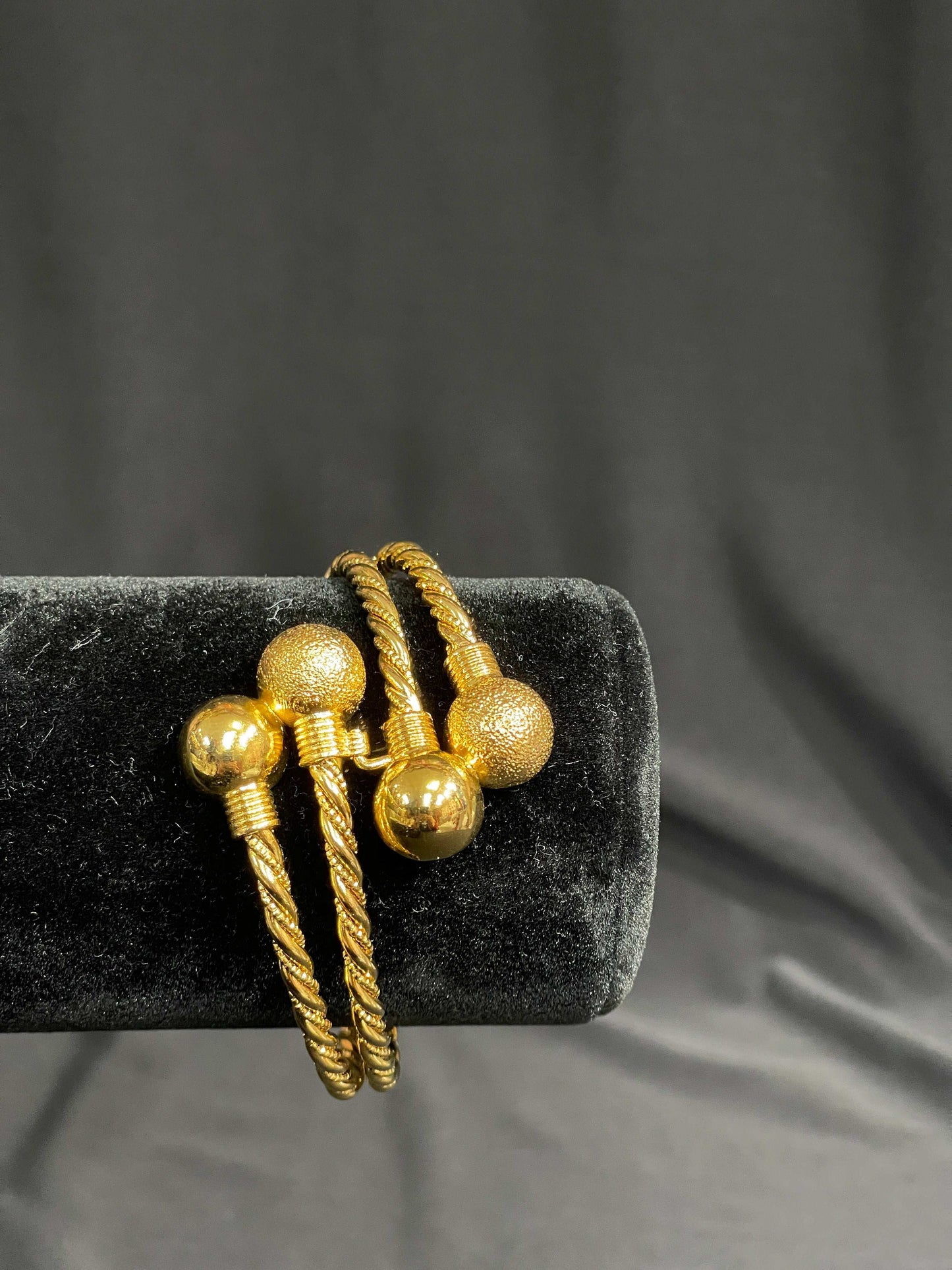 Elegant Mabroma Gold Bracelet by Palestinian Elegance with twisted band and gold textured and smooth ball ends