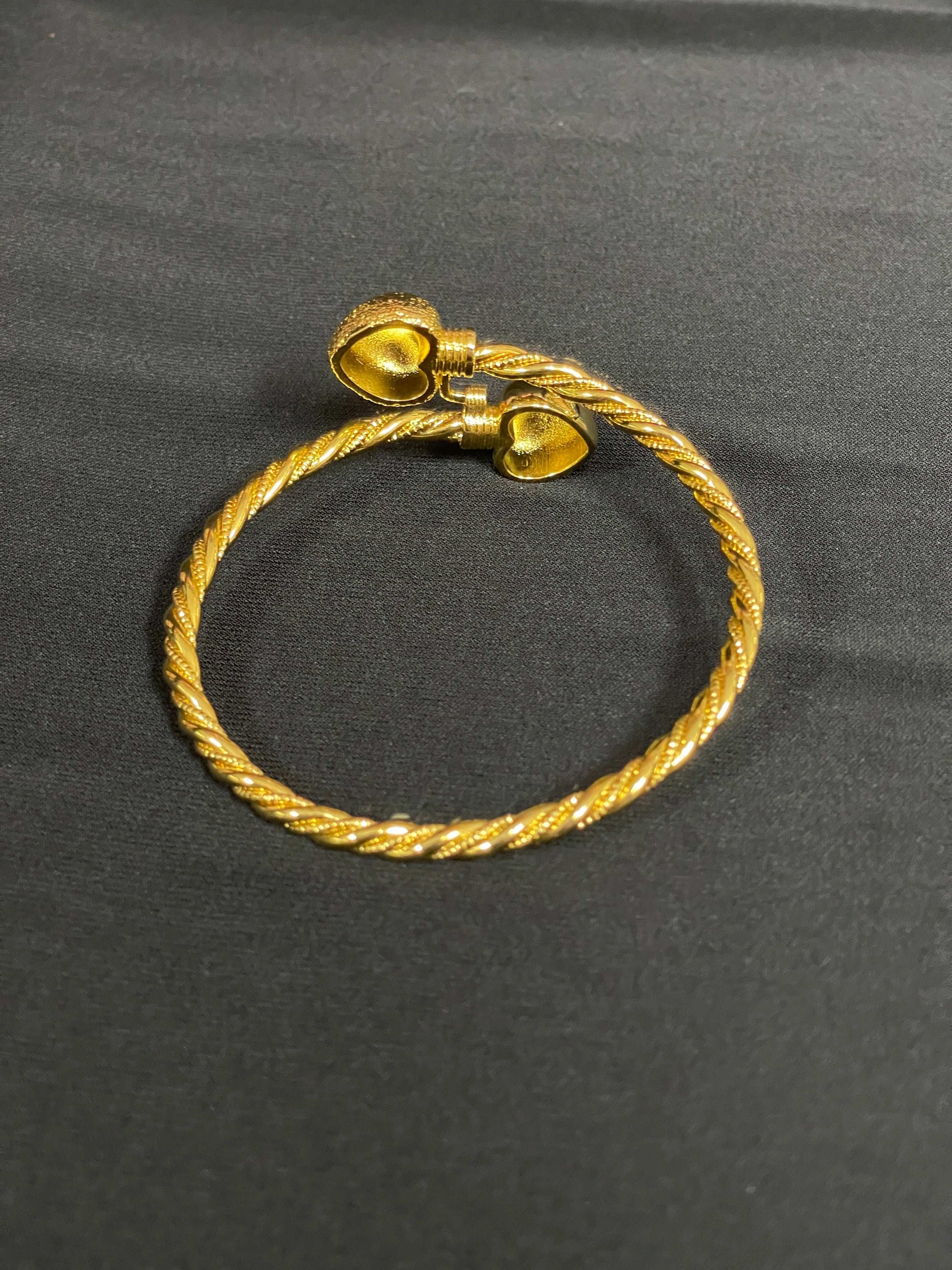 Mabroma Gold Heart Bracelet by Palestinian Elegance with twisted band and heart-shaped ends