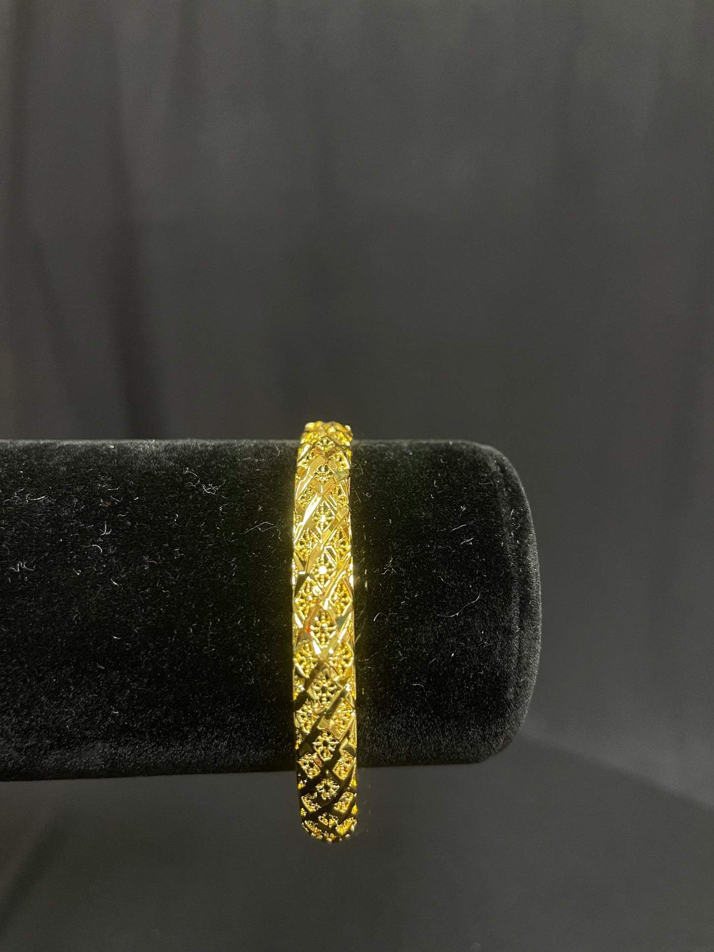 Palestinian Elegance imitated gold Palestinian gold bangle bracelet with intricate detailing on black display