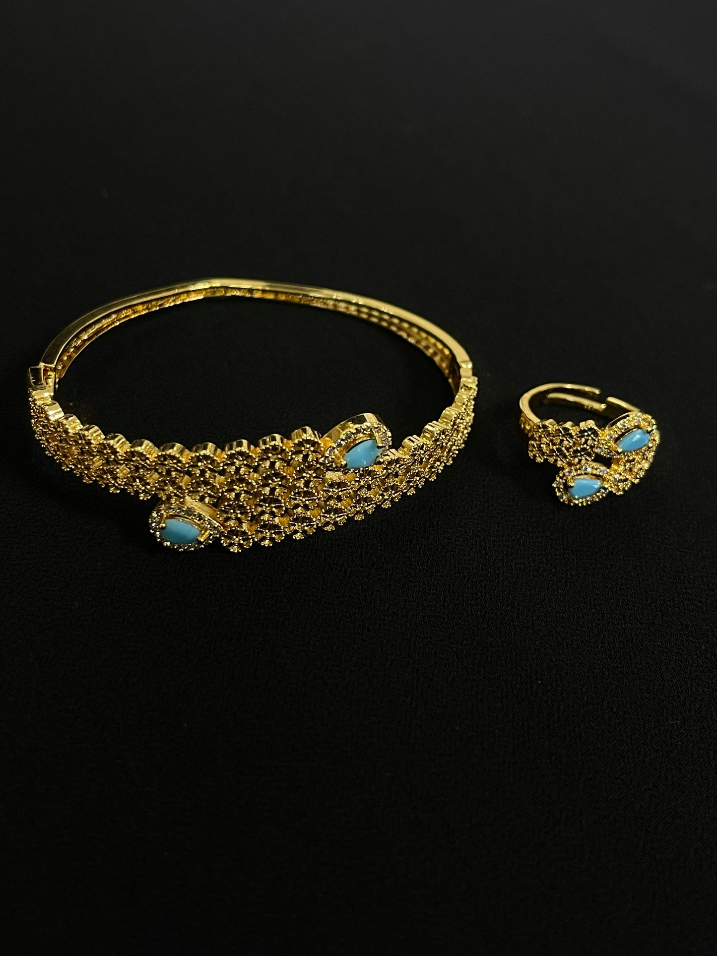 Palestinian gold jewelry set with intricate gold design and turquoise gemstones on black background
