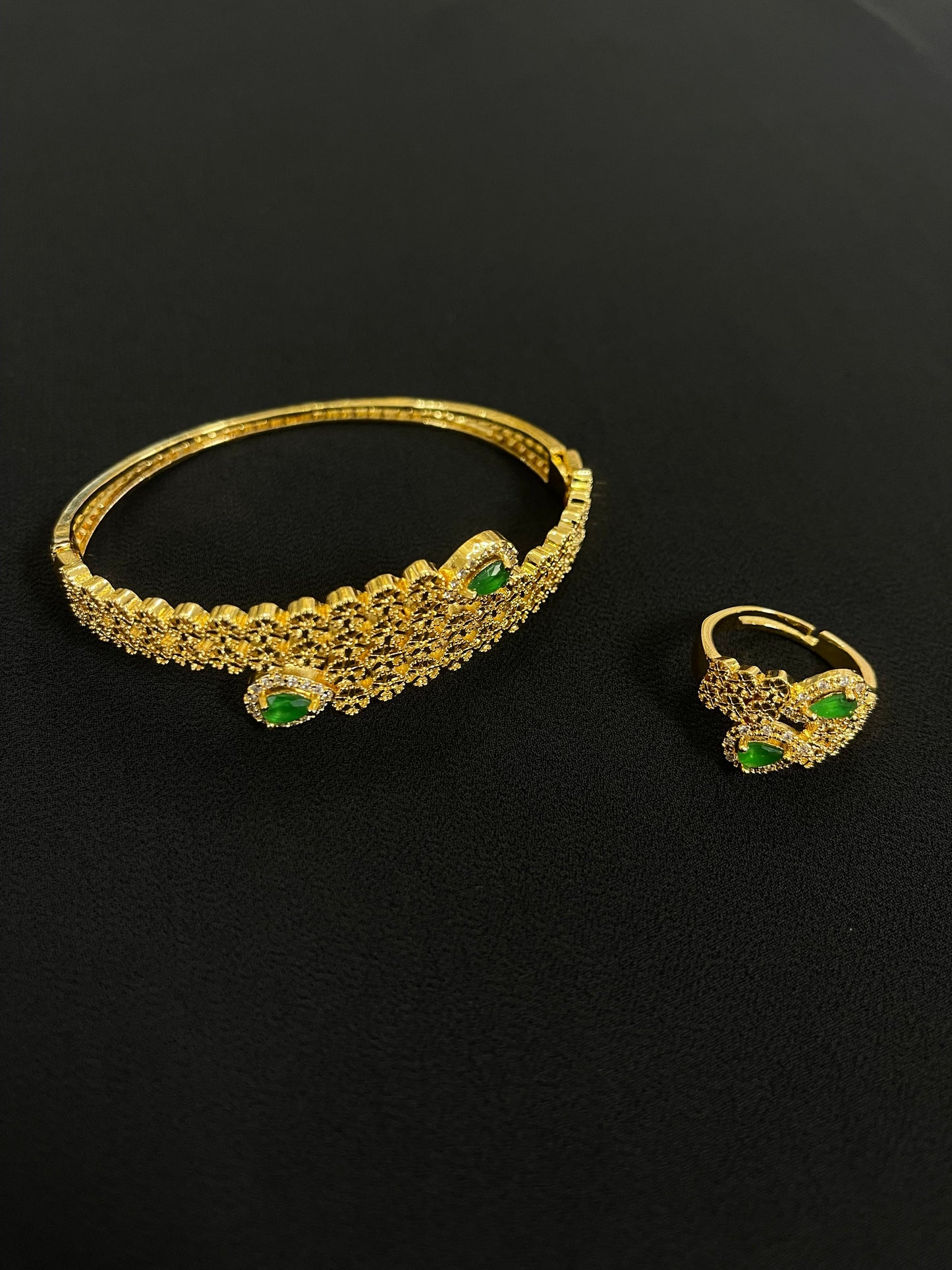 Palestinian gold jewelry set featuring gold bracelet and ring with green stones from Palestinian Elegance