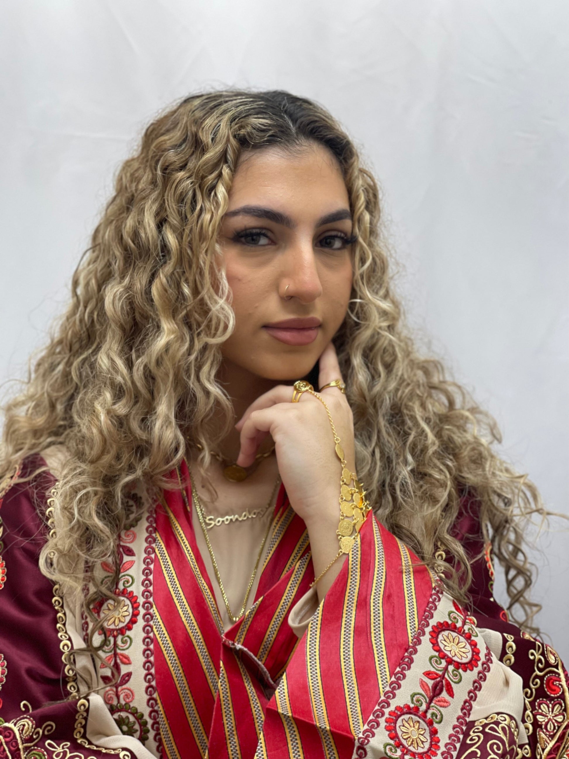 Woman wearing Palestinian Elegance gold kaff hand jewelry with traditional embroidered attire