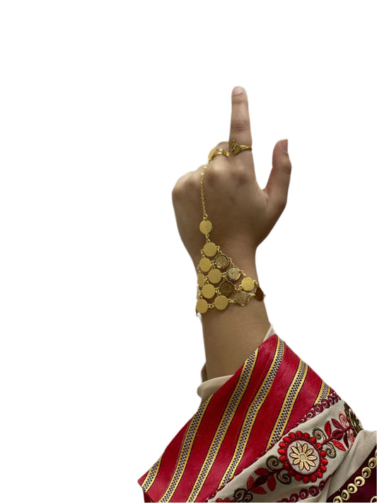 Gold kaff hand jewelry on wrist and finger with traditional clothing sleeve by Palestinian Elegance